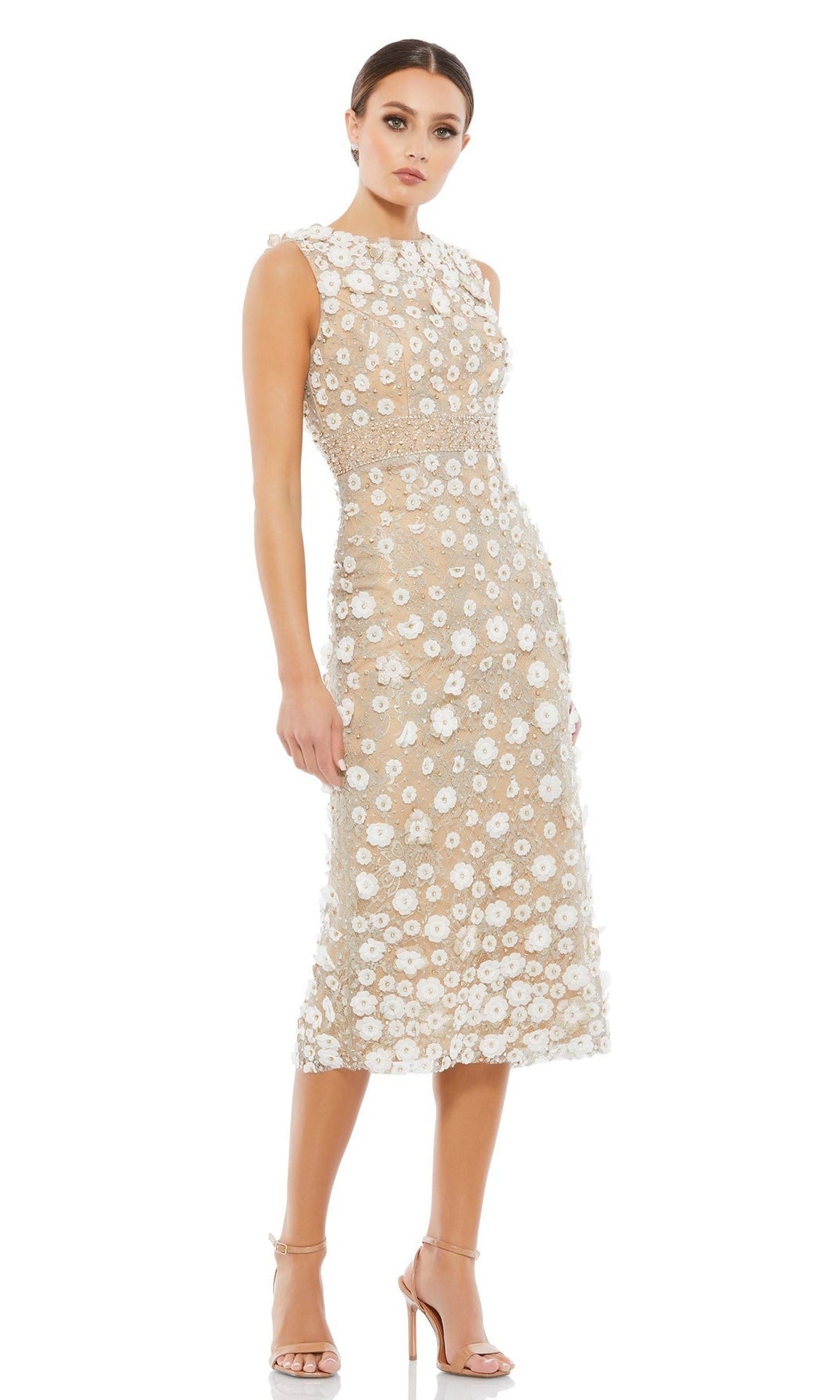 A woman models the Mac Duggal 67853 knee-length party dress in beige with white floral appliqués and nude high-heeled sandals, standing against a white background.